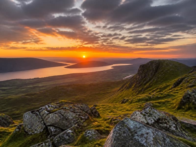 Sunset over a Scottish loch and hills